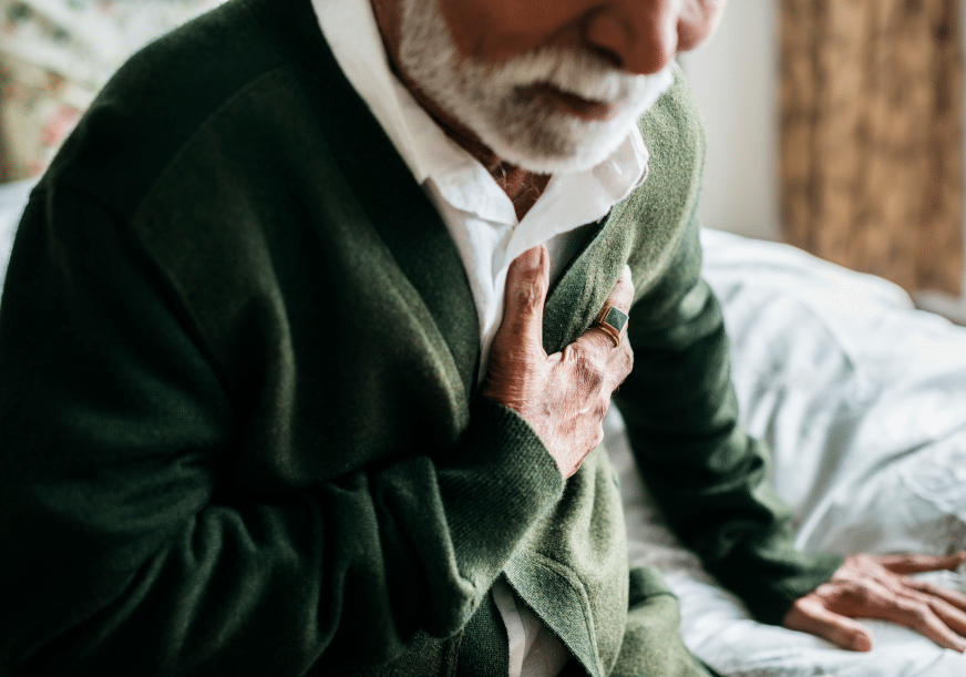 an older man clutches his chest