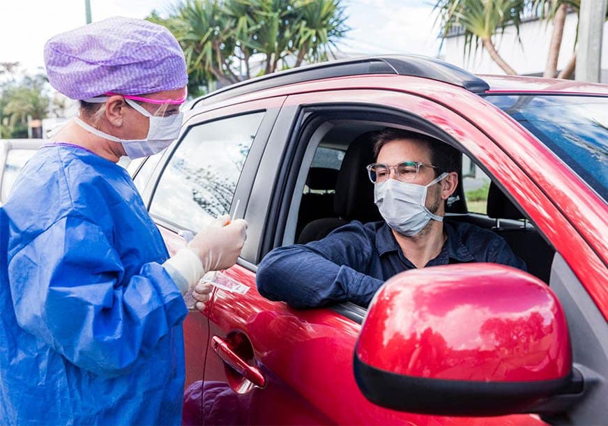 a doctor gives a drive by covid test