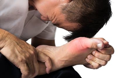 a man clenches his toe in pain