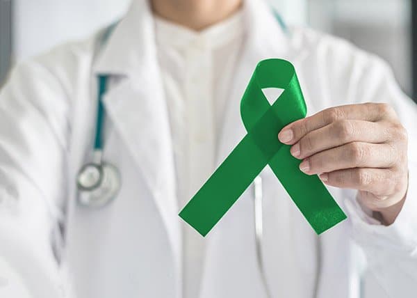 a doctor holds a green ribbon